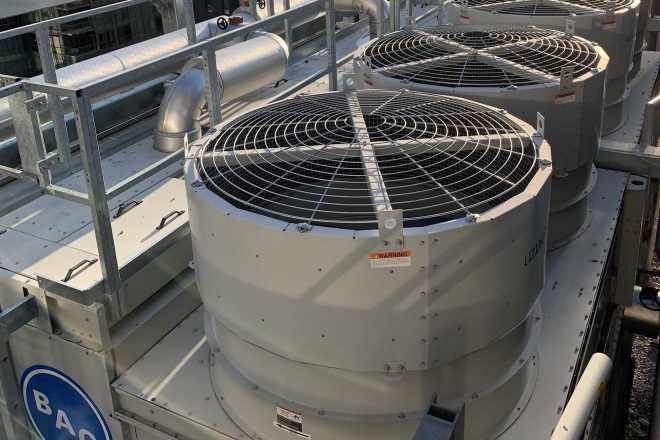BAC cooling towers installed on the rooftop of a building at Victoria sur le Parc, with industrial ventilation ducts in the background