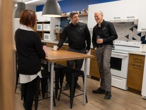Three coworkers from SCV Enduite enjoying a casual coffee break in a warm and modern office kitchen. The image captures workplace well-being, human connection, and informal exchanges among team members.
